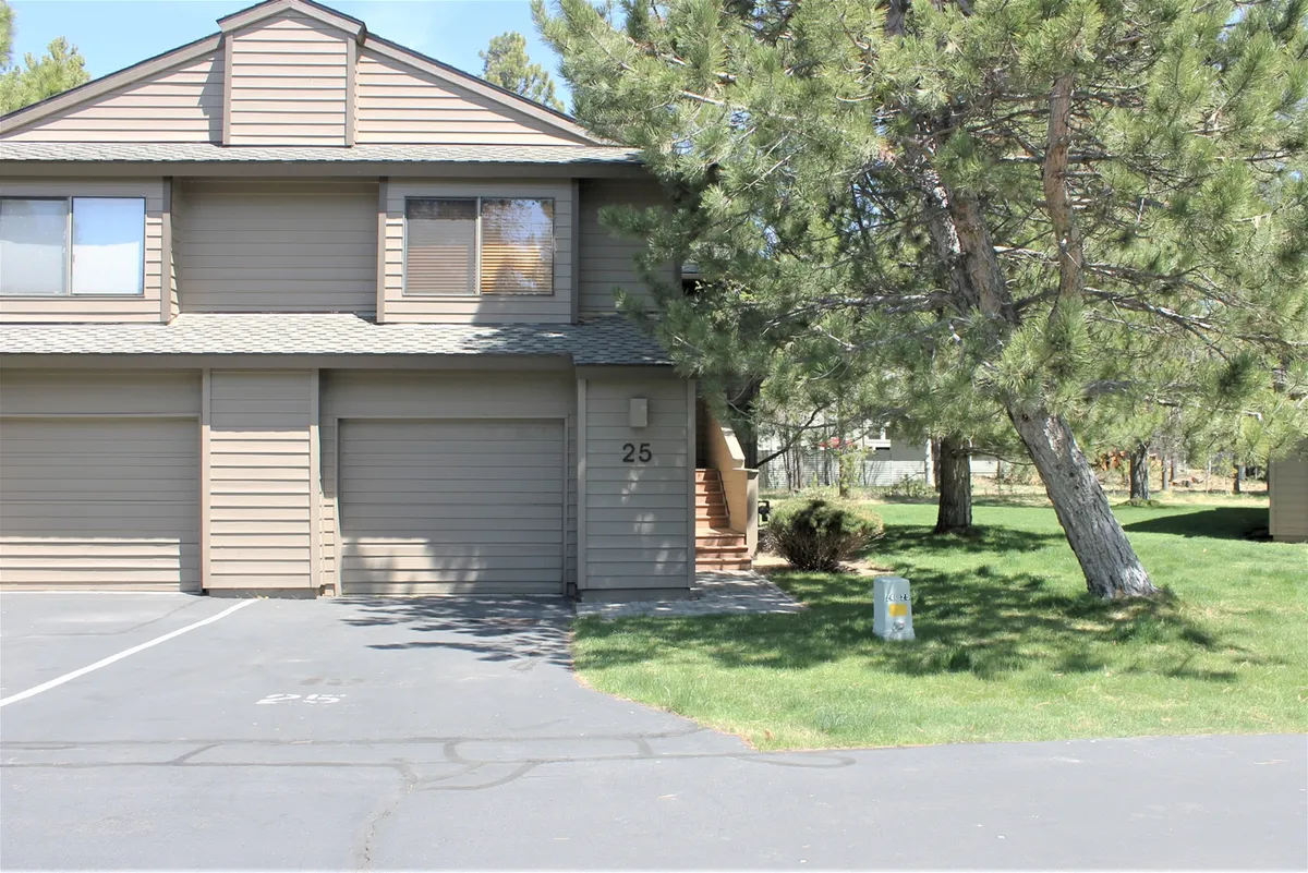 A view of the home's front entrance and garage doors, framed by a landscaped area. The welcoming setting suggests a space where families can gather, play outside, and enjoy the outdoors together.