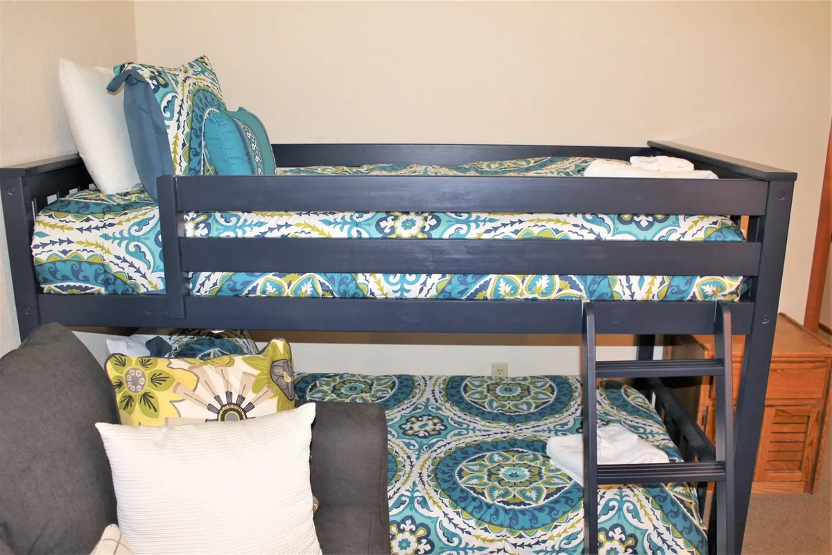 A playful, comfortable bunk room with colorful bedding and a cozy sofa. The space invites relaxation and serves as a private retreat for guests, whether for bedtime stories or quiet downtime after a day of adventure.